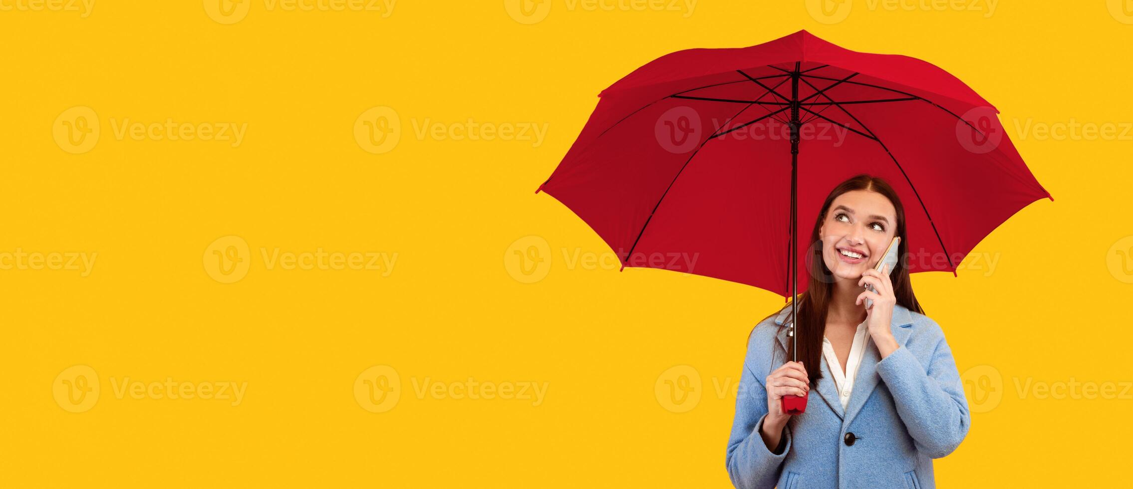 Nice Conversation. Portrait of cheerful lady talking on cell phone, holding umbrella, looking up at copy space photo