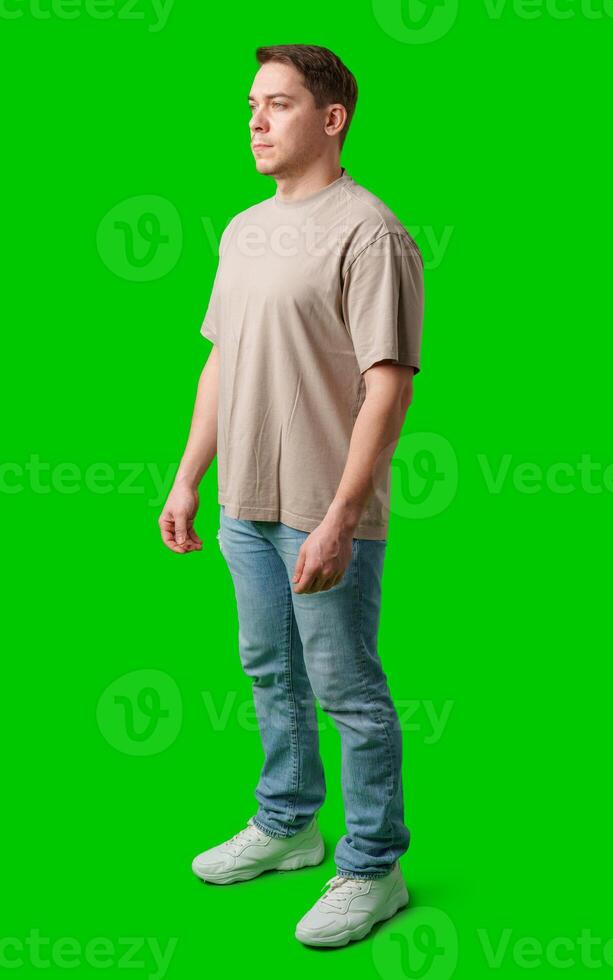 A young man stands confidently in casual attire on a vibrant green background photo