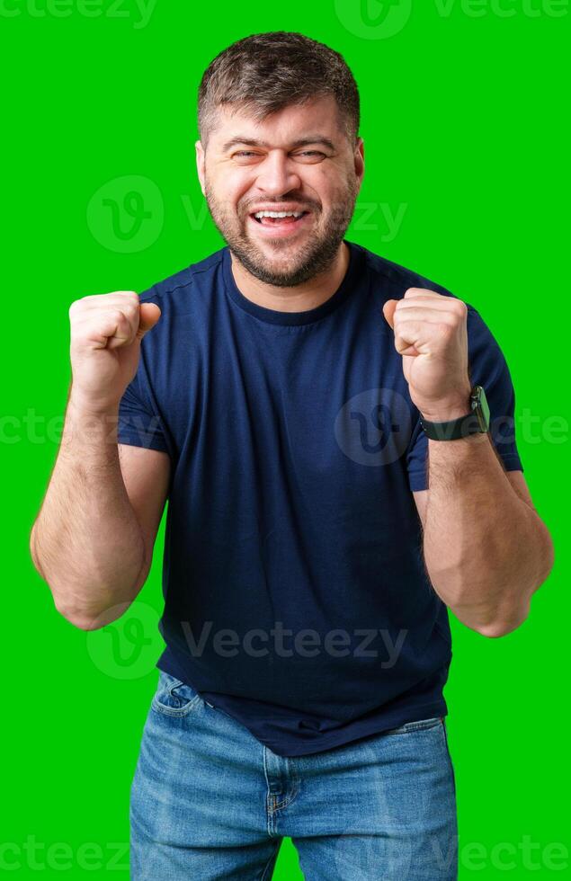 A strong man with fists raised, smiling confidently, on a bright green background photo