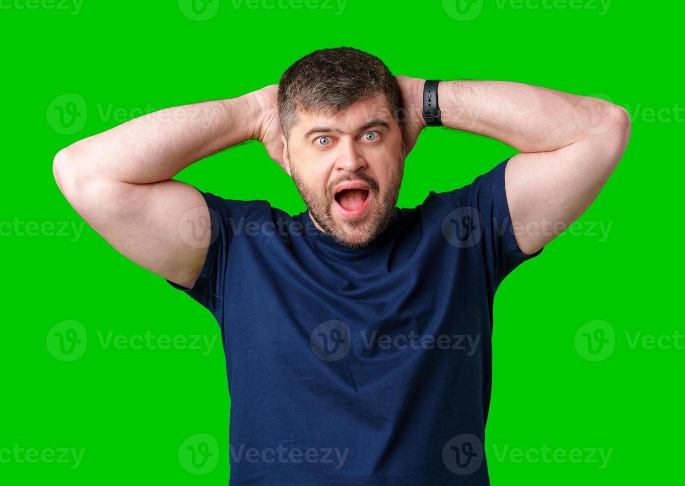 A surprised man expresses shock against a bright green background photo