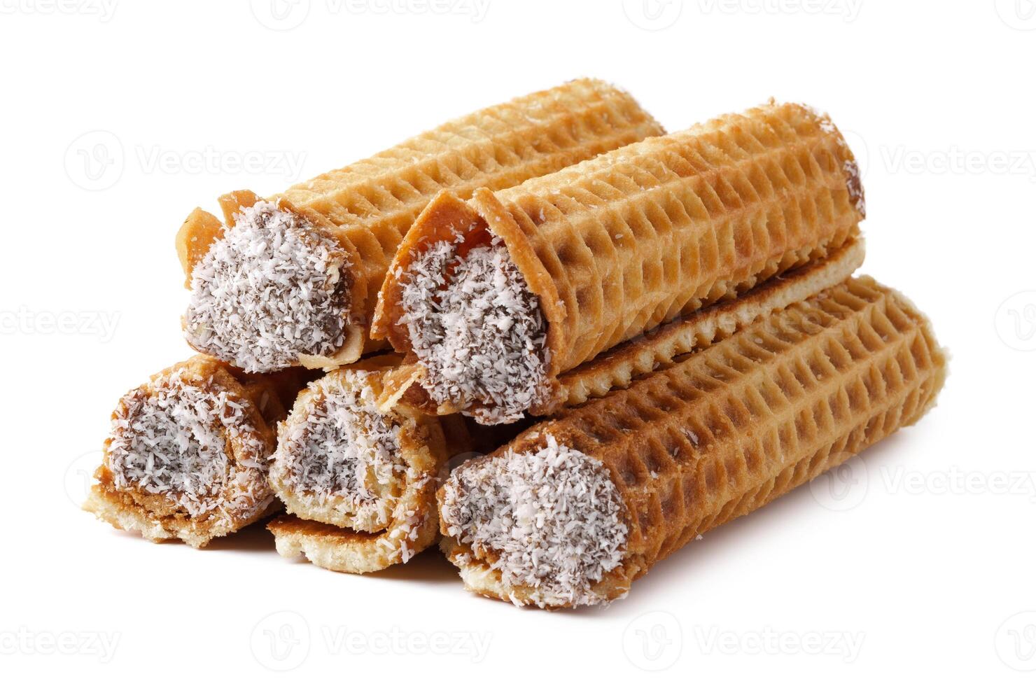 Delicious rolled wafers filled with chocolate cream and coated in coconut flakes on a white background photo