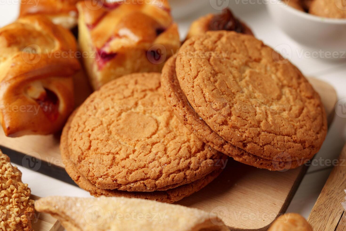 Freshly baked cookies surrounded by assorted pastries and baked goods in a cozy setting photo