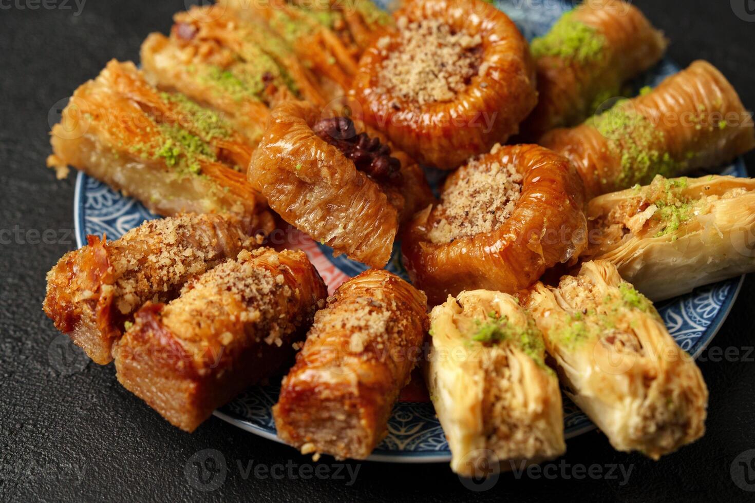 Diverse assortment of traditional pastries arranged on a decorative plate during a festive gathering photo