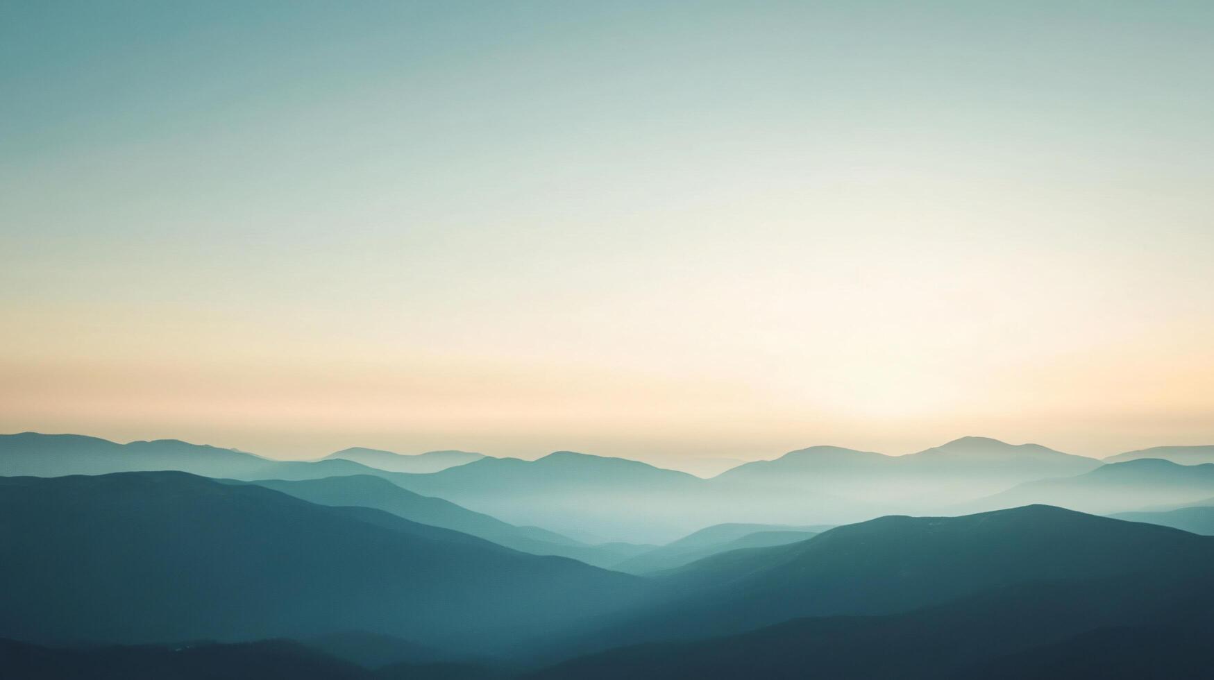 Layers of mountain ridges fading into the distance under a soft pastel sky at sunset photo
