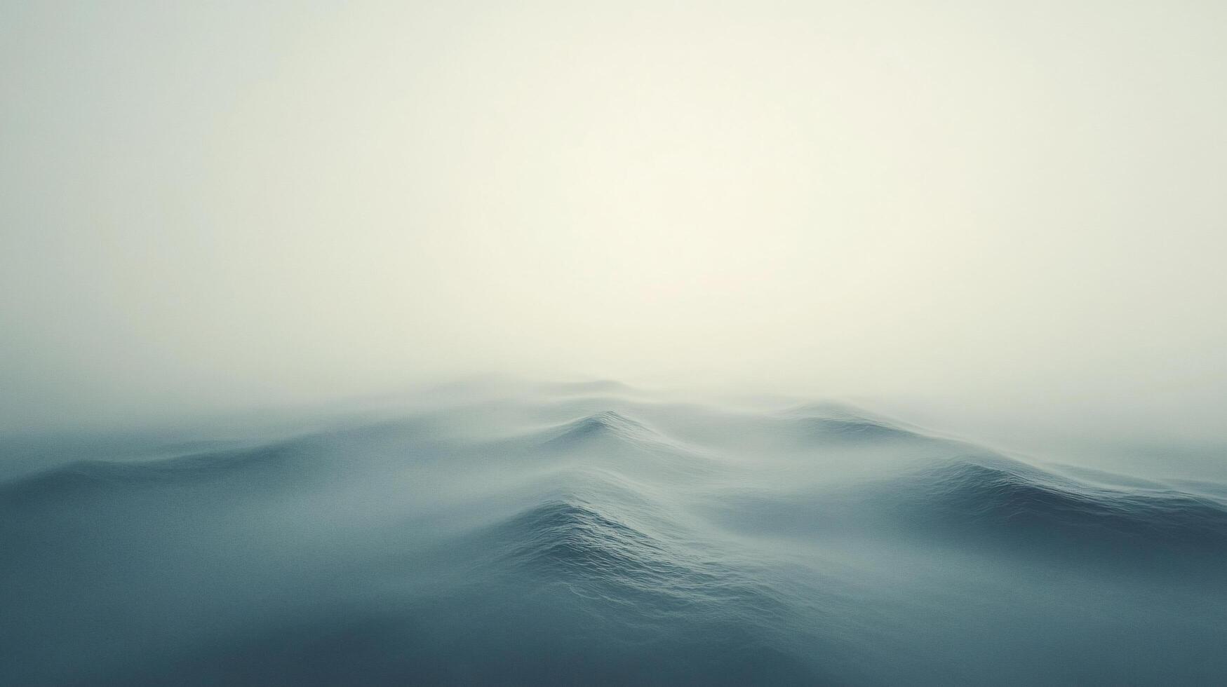 Soft waves are barely visible through thick fog creating a serene and minimalist seascape photo