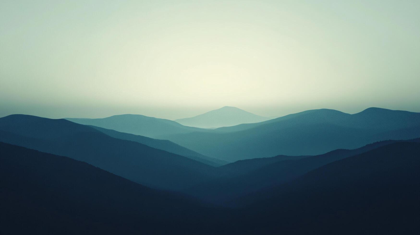 Soft light illuminates the peaks of a mountain range, creating a serene and minimalist landscape photo