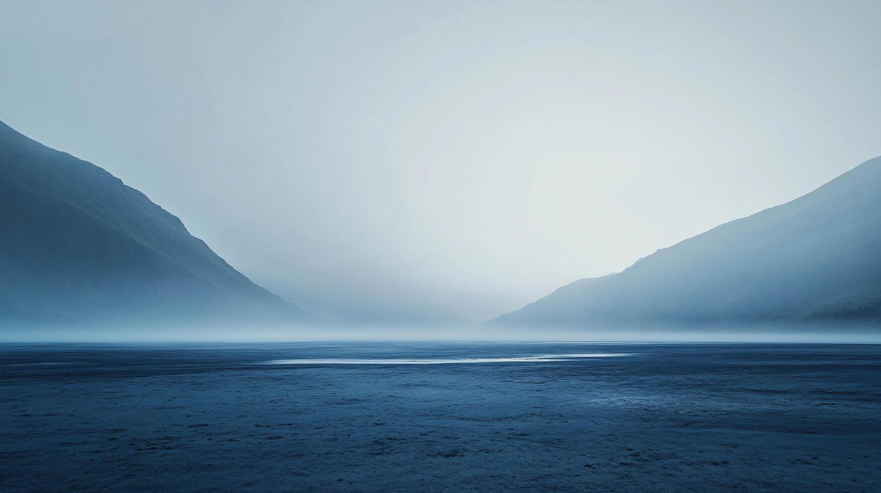 Low fog covering a lake at the foot of two mountains in a cold and mysterious atmosphere photo