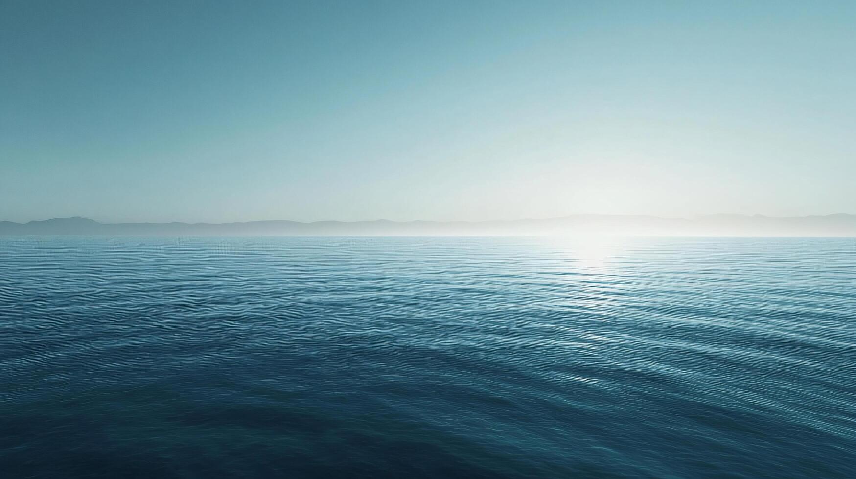 Tranquil ocean scene reflecting sunlight, with misty mountains visible in the distance photo