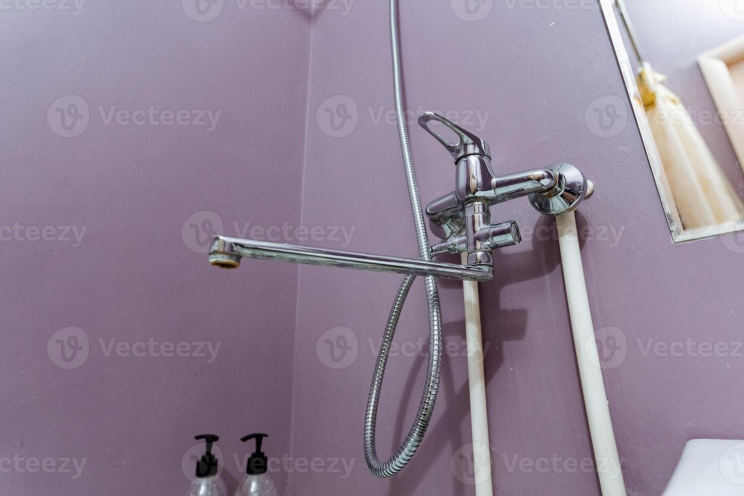 a bathroom with purple walls and a shower head photo
