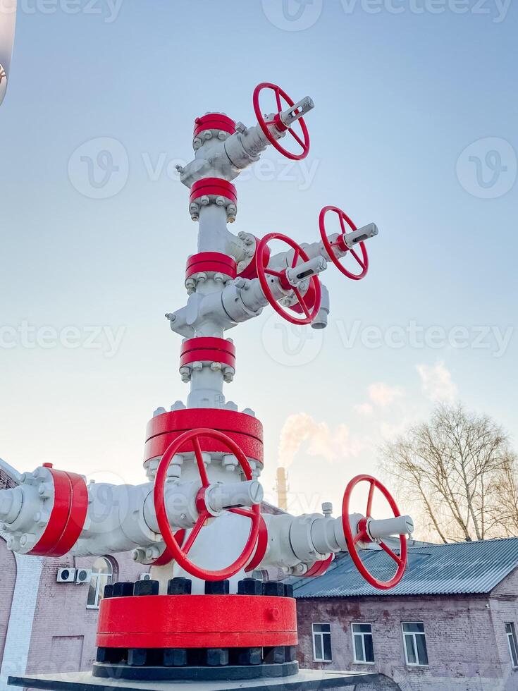 A pipe that is colored red and white and features numerous valves attached to it, suggesting its purpose might be related to gas or liquid transport in a building or industrial setting photo