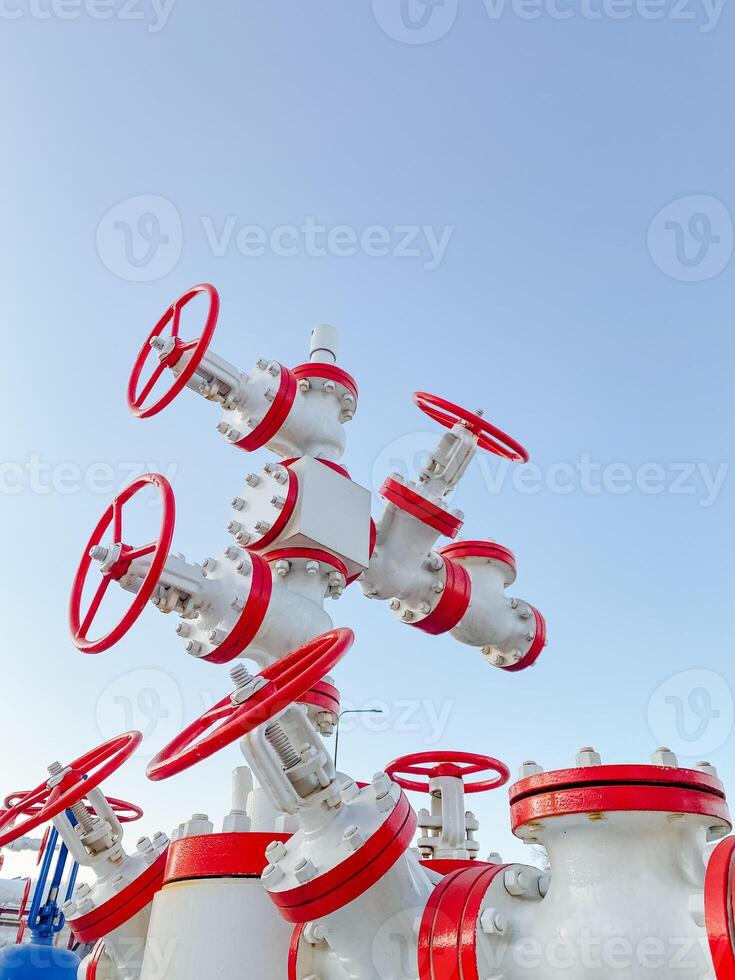 A collection of white pipes equipped with vibrant red handles stands out beautifully against the backdrop of a clear blue sky, creating a colorful and striking visual scene photo