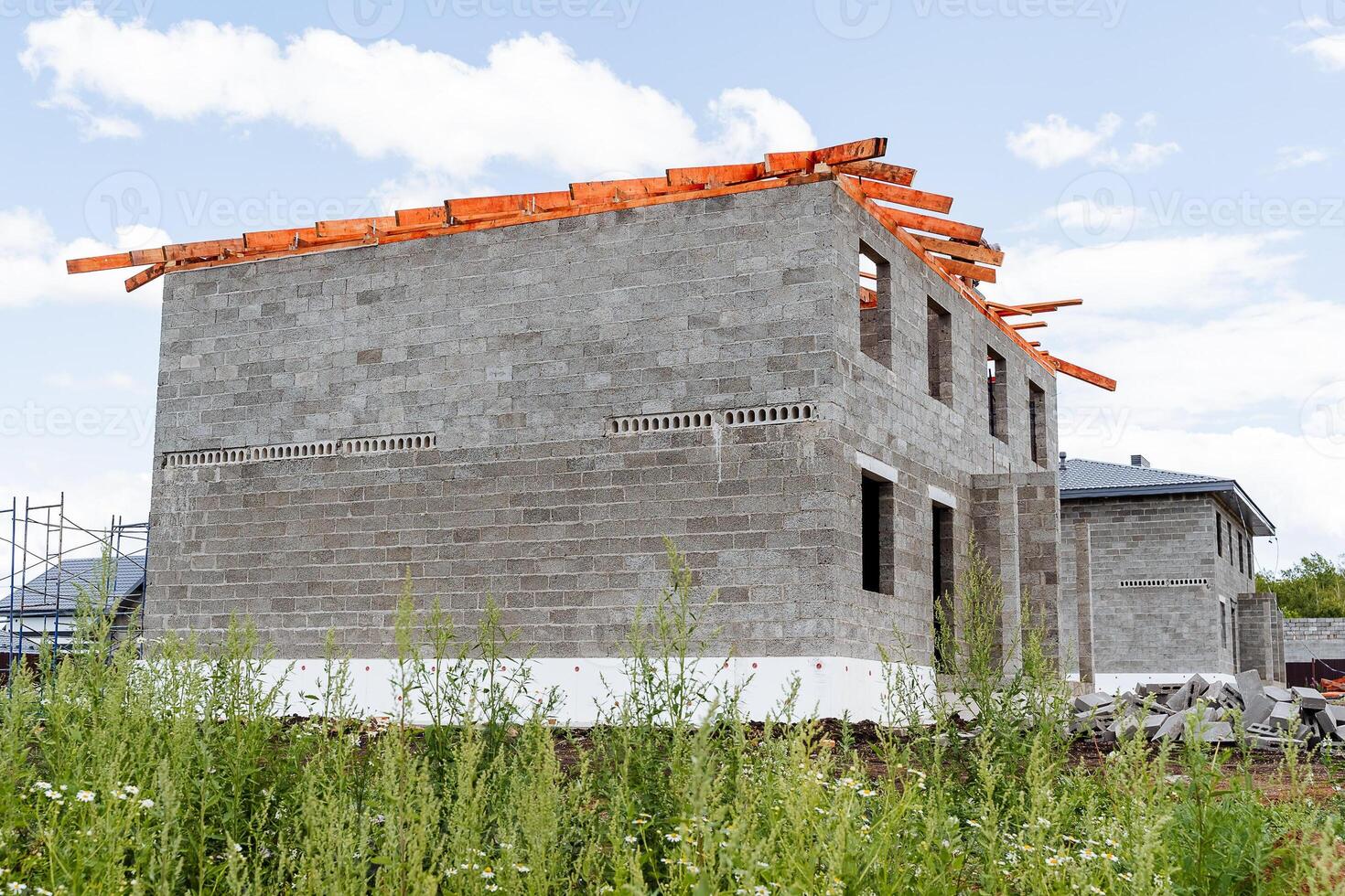 A new house is currently under construction, which is utilizing highquality bricks and sturdy wooden beams for strong support, based on the detailed building plan that has been provided photo