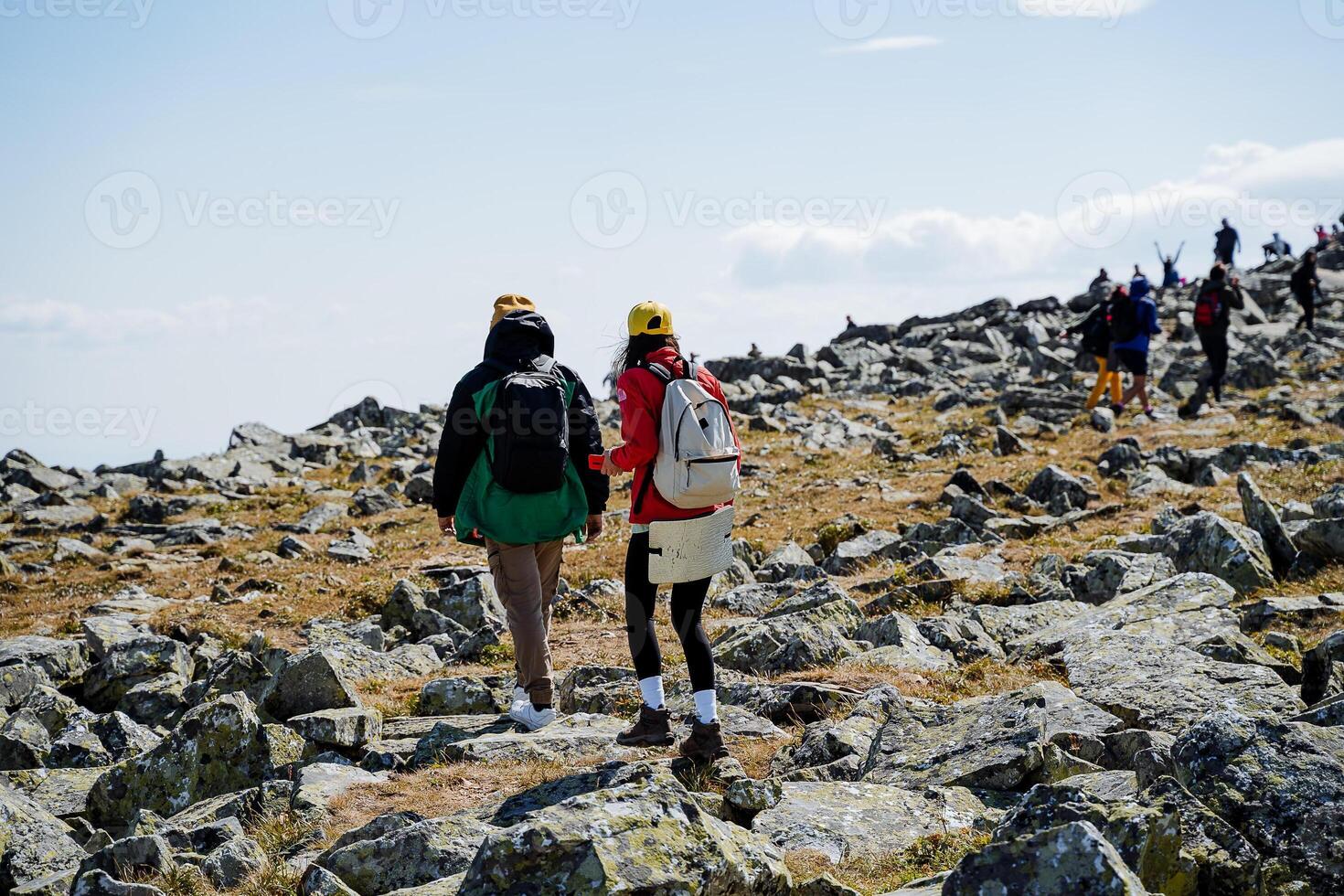 Two skilled hikers expertly navigate through the rugged and challenging terrain while exploring a breathtaking and stunning mountain trail photo