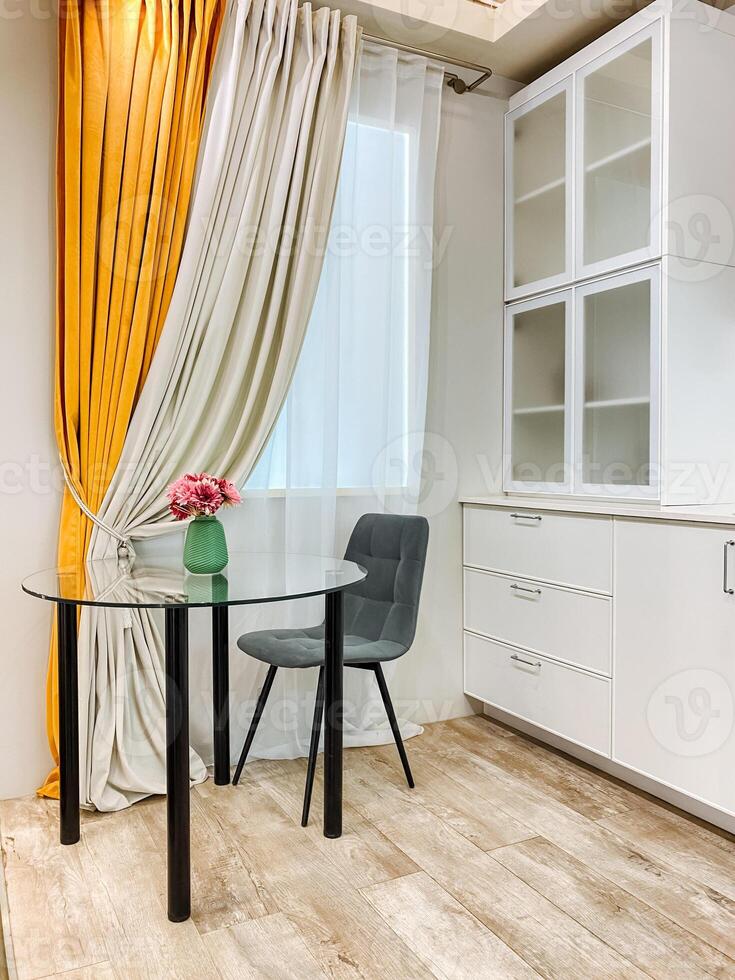 Imagine a cozy kitchen that features a dining table along with chairs, all positioned right in front of a lovely window that allows natural light to fill the space beautifully photo