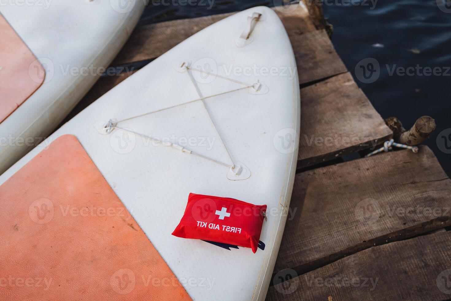 A paddle board equipped with a comprehensive first aid kit on top of it, ensuring safety while enjoying water activities, can be an essential item for outdoors enthusiasts photo