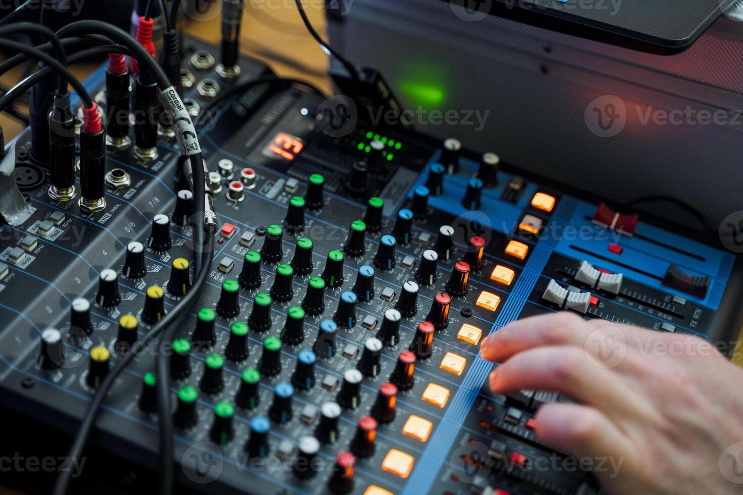 Hand pressing button on mixer, audio equipment in use photo