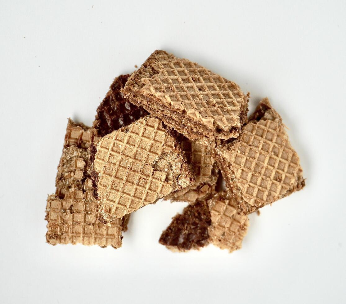 Group of crushed chocolate wafer biscuits isolated on horizontal white background from top angle view. photo
