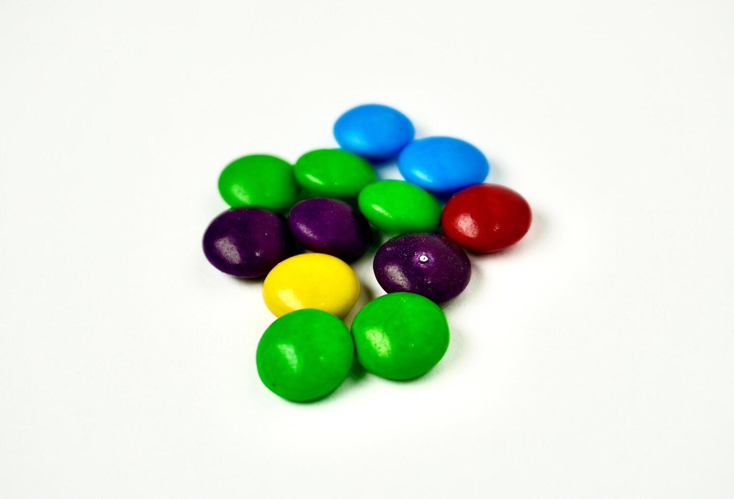 Group of colorful small round rainbow chocolate candy isolated horizontal white background. photo