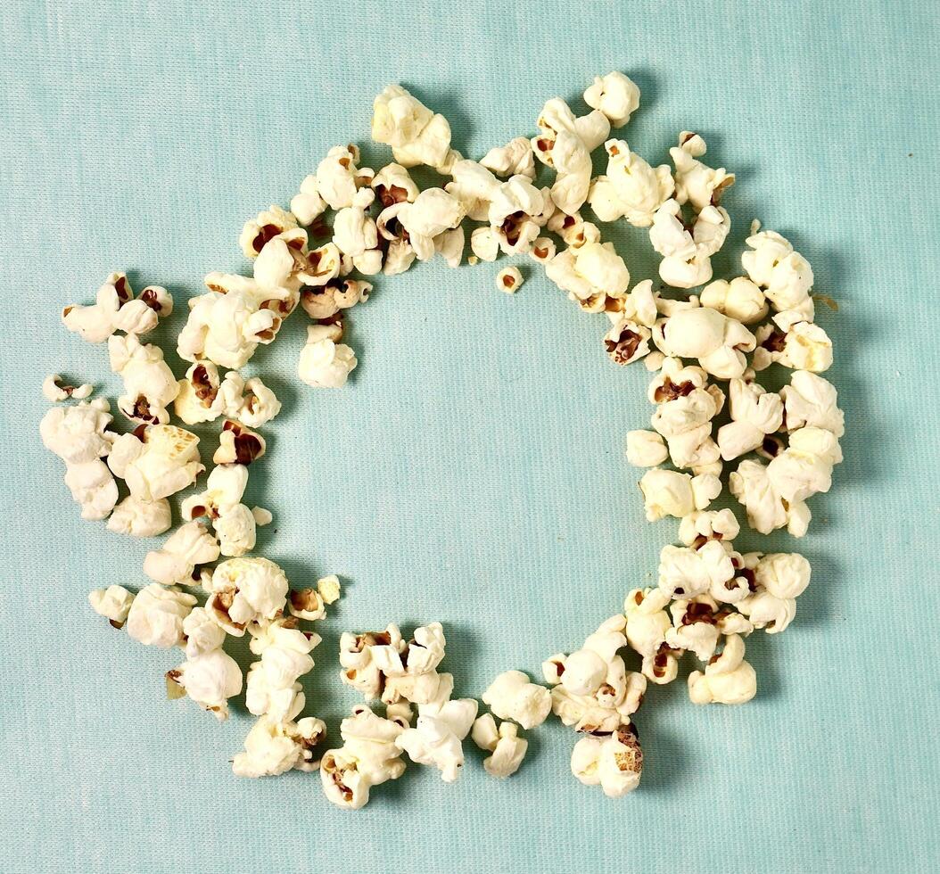 Crunchy salted pop corn snacks with round empty copy space isolated on horizontal background from top angle view. photo
