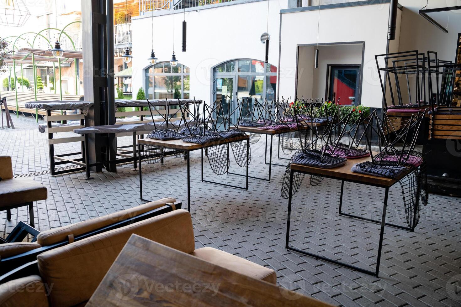 The restaurant is currently empty, and within it can be seen an array of tables and chairs stacked awkwardly, forming a surreal and intriguing sight that certainly invites curiosity photo