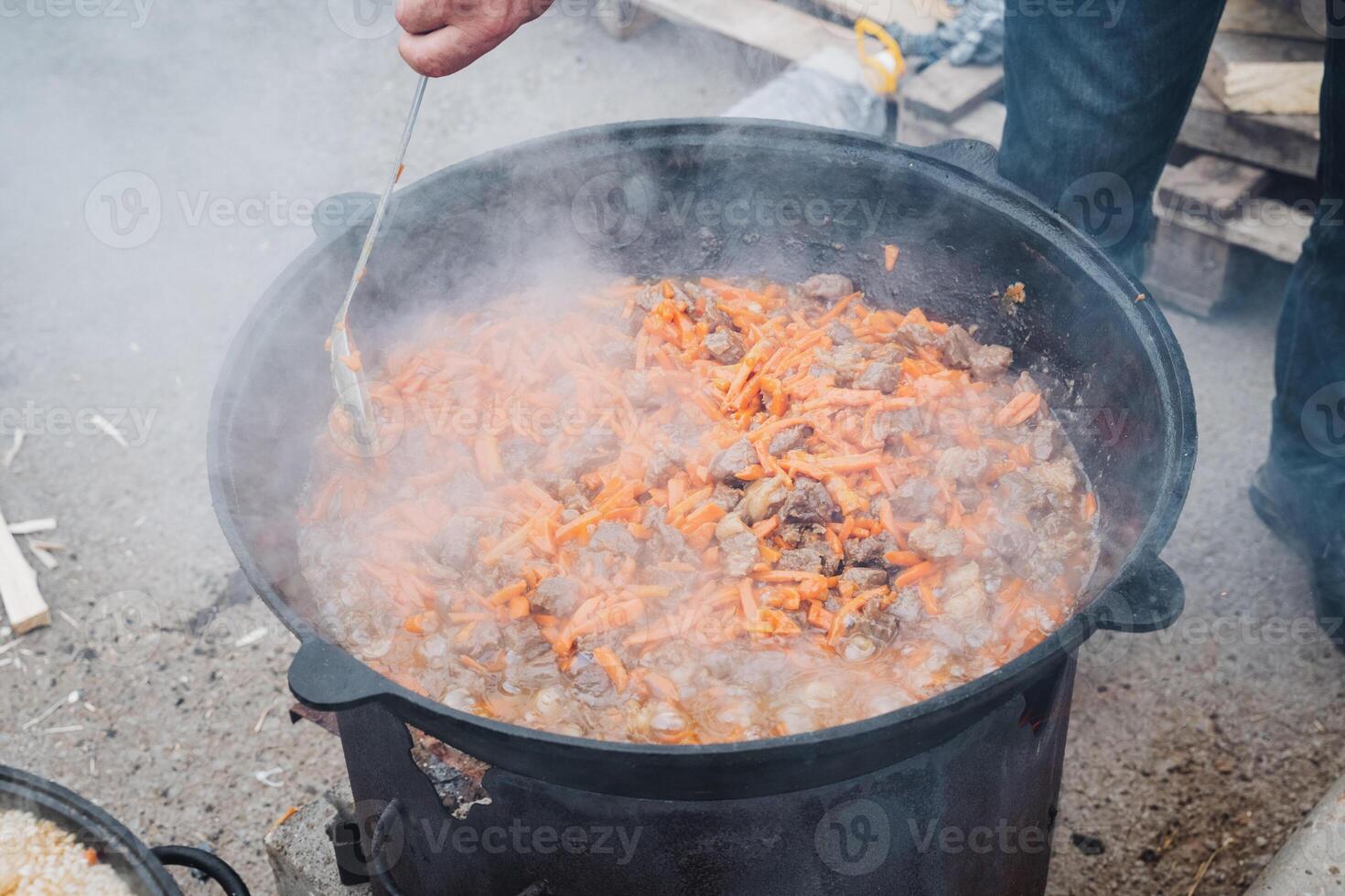 A person is slowly and carefully stirring a pot filled with delicious food using a spoon, ensuring that all ingredients are mixed thoroughly for the perfect flavor and texture photo