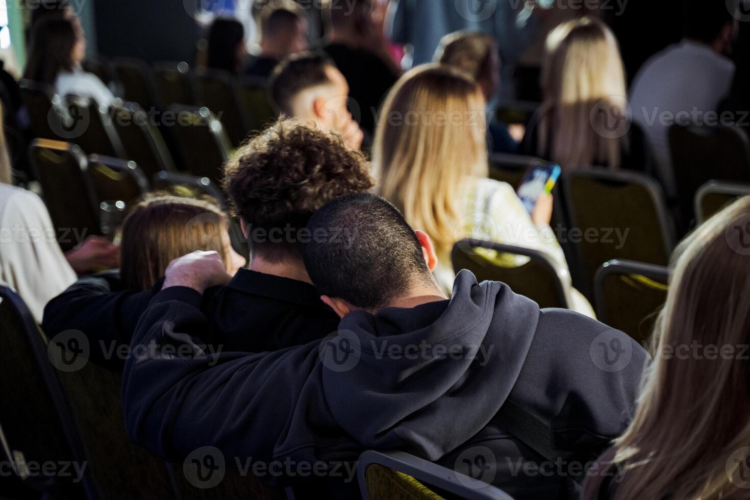A crowd in a room sharing a gesture of unity during an event photo