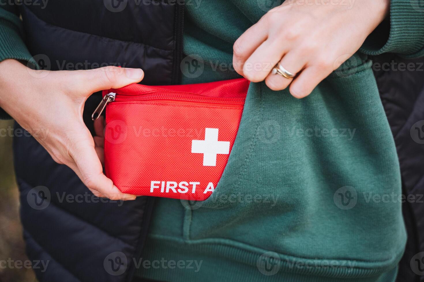 An individual is confidently holding a wellstocked first aid kit, which is conveniently tucked into their side pocket, while wearing comfortable and casual sportswear for their activities photo