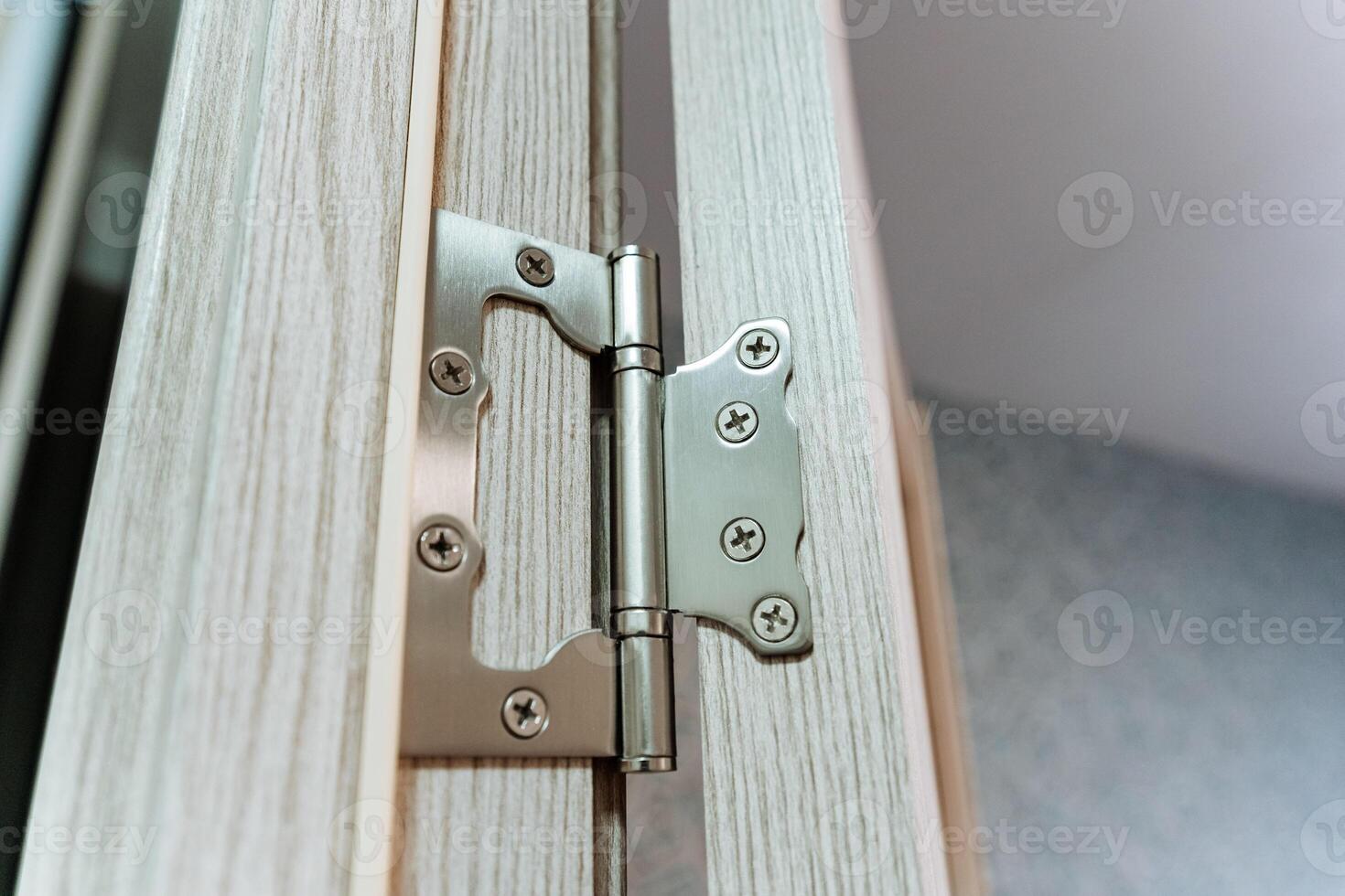 This image shows a closeup of a wellattached door hinge on a beautifully crafted wooden door, highlighting the exceptional craftsmanship and quality materials in its design photo