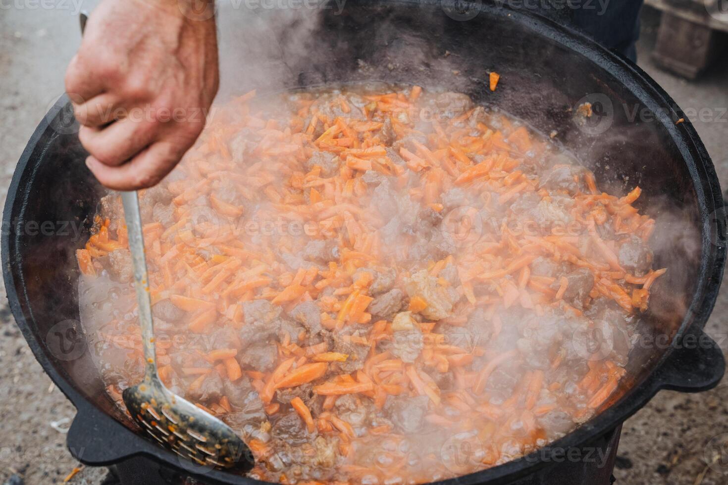 A person is carefully stirring a pot of delicious food using a ladle in their kitchen, ensuring that the ingredients blend together perfectly for an amazing meal to be enjoyed later photo