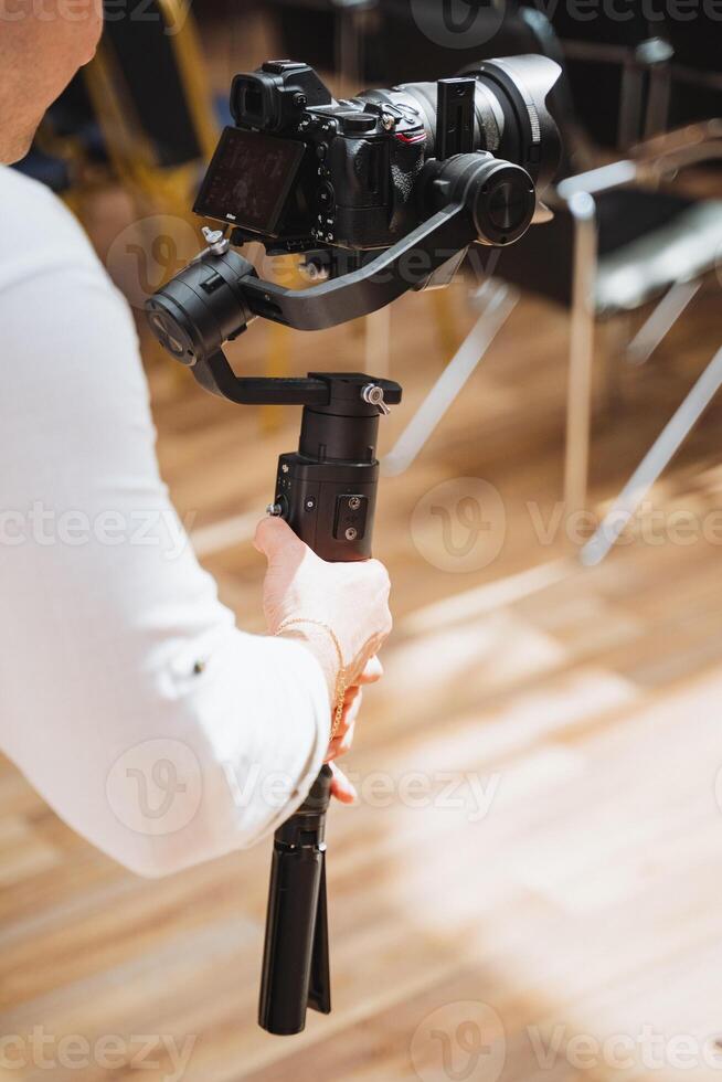 Person setting up camera on tripod for event on wood flooring photo