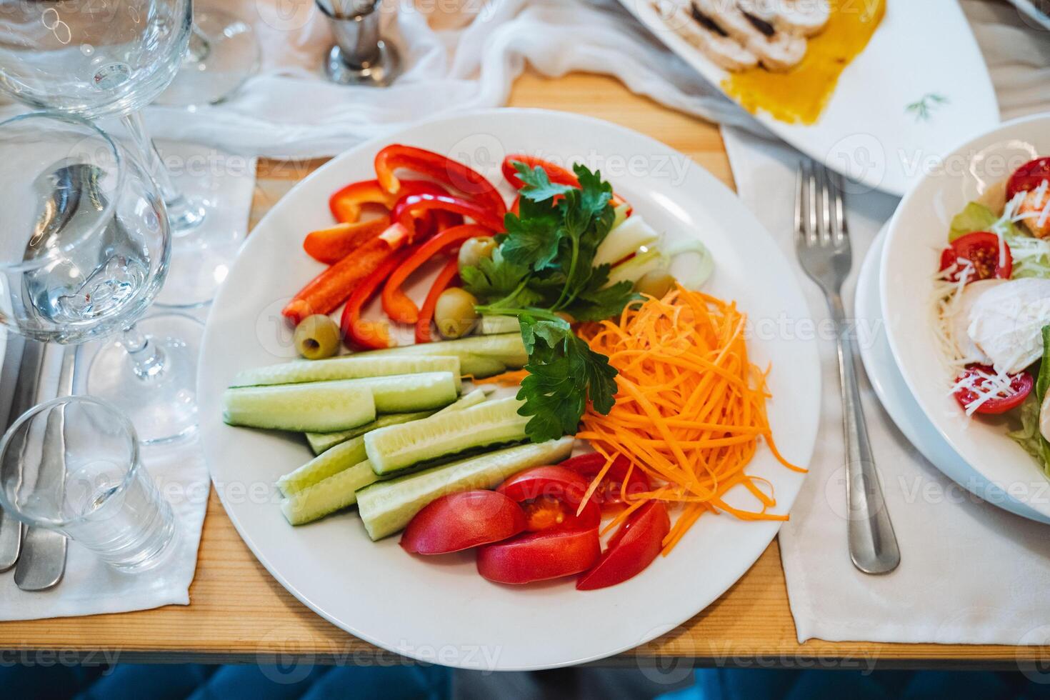A plate of vegetables on a table with a fork and spoon photo