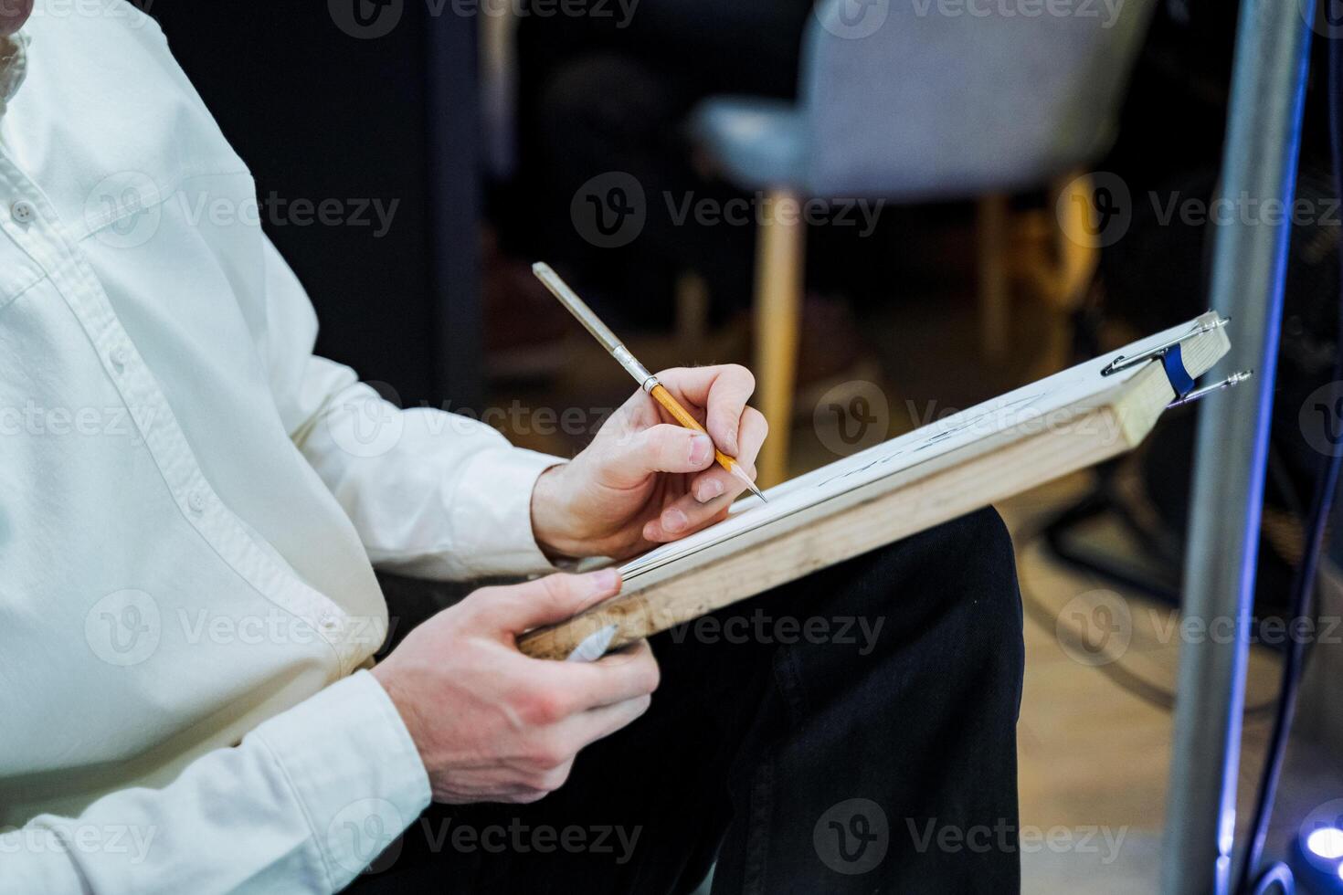 A man is jotting down notes on a clipboard with a pen photo