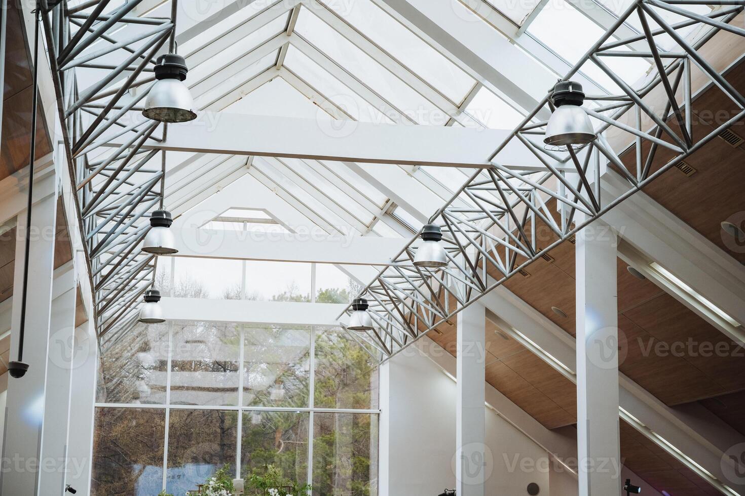 A building made of wooden fixtures with a glass roof and numerous windows photo