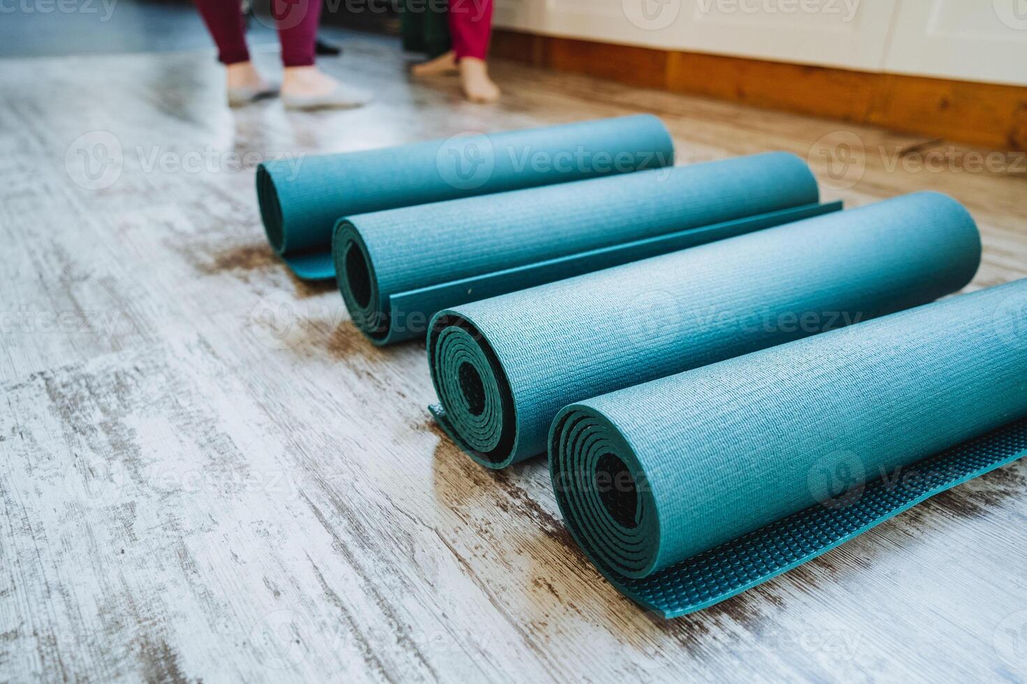 Rectangular electric blue and magenta yoga mats stacked on wooden flooring photo
