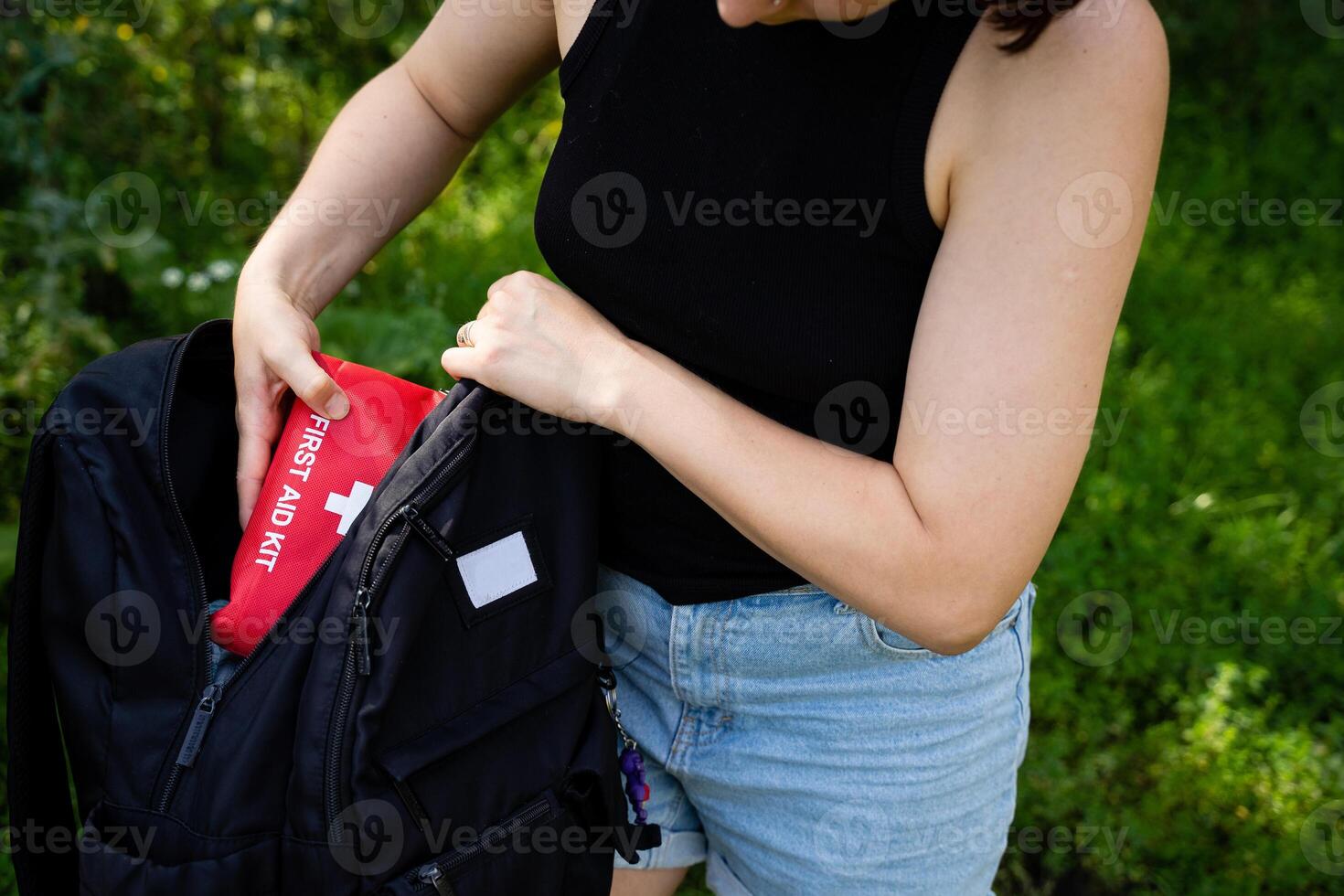 A Person is Engaged in Packing a Backpack Filled with Essential Emergency Supplies While in the Beautiful Nature photo