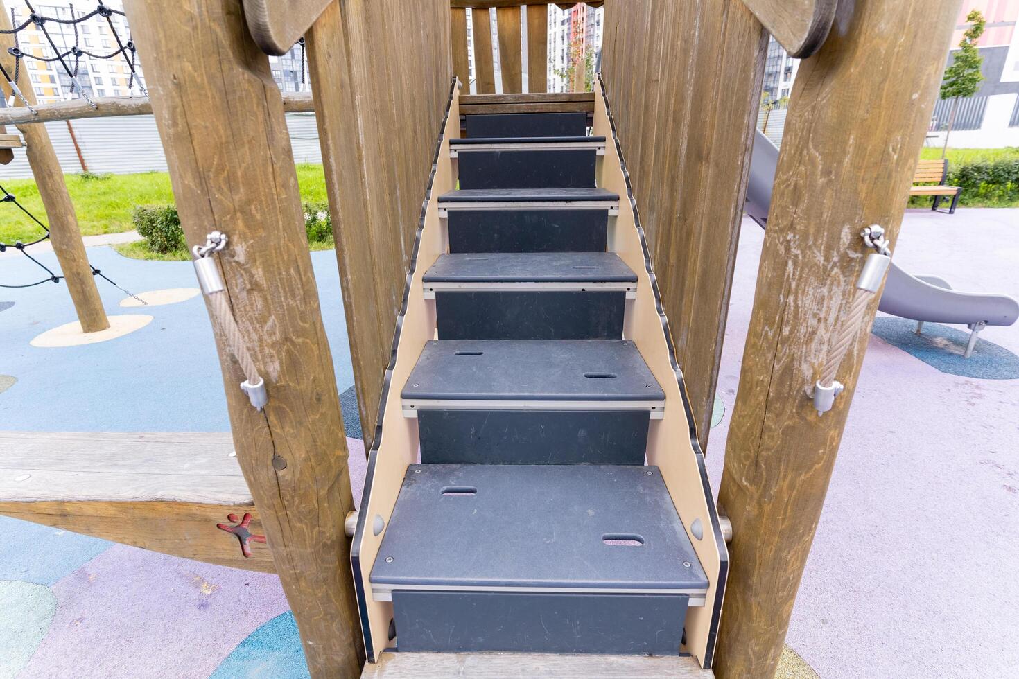 A quaint wooden playground complete with stairs and a slide for fun photo