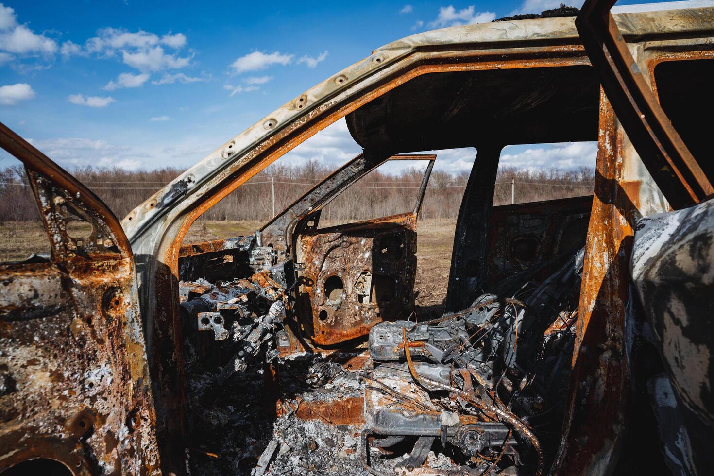 burnt fat of a car abandoned on the side of the road in a field, a burnt car, a car crime, destruction of property. photo