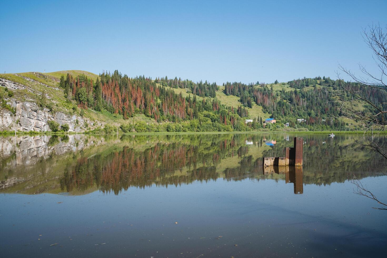 Imagine a serene landscape with a beautiful lake surrounded by towering mountains, reflecting trees on its tranquil surface, creating a mesmerizing view of natures beauty photo