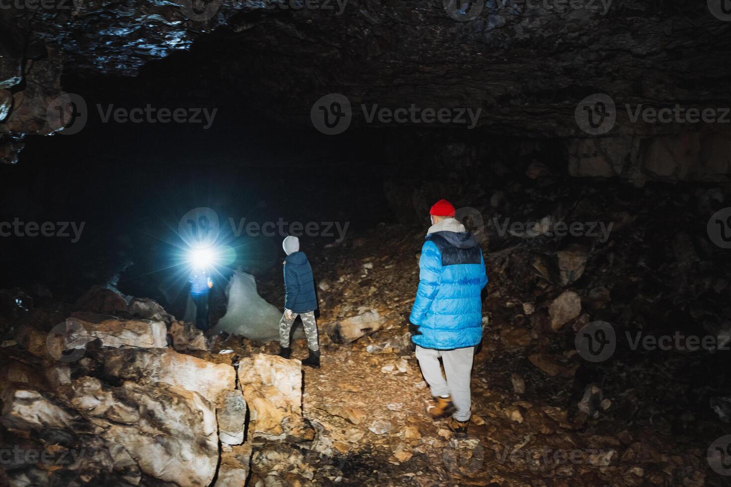 A group of explorers is embarking on an exciting adventure as they navigate through a mysterious cave located deep underneath the Earths surface photo