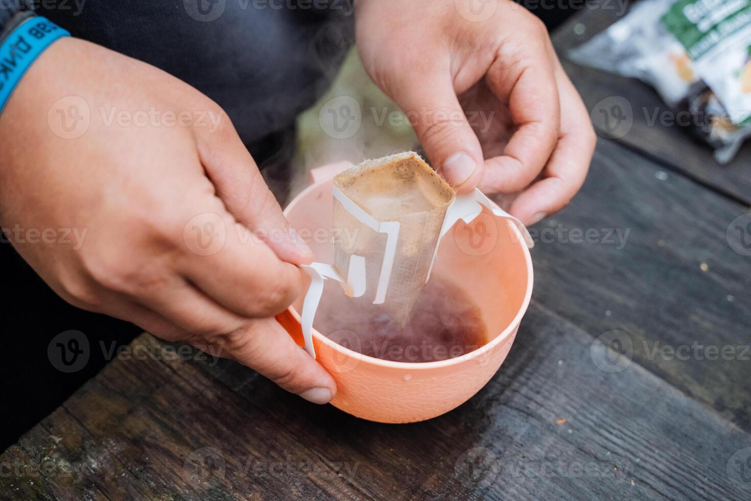 In the image, someone is transferring coffee from a bag to a cup. The scene is related to food, recipe, fluid, ingredient, cooking, cuisine, dish, drink, and cookware and bakeware photo