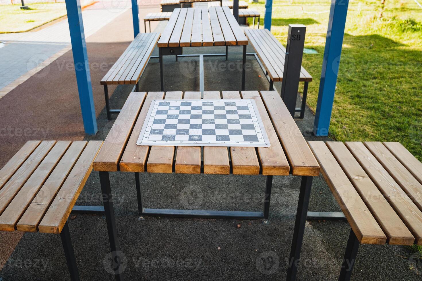 An elegantly crafted wooden picnic table, featuring a beautifully arranged chess board strategically placed on its surface, perfect for outdoor gatherings and leisurely games photo