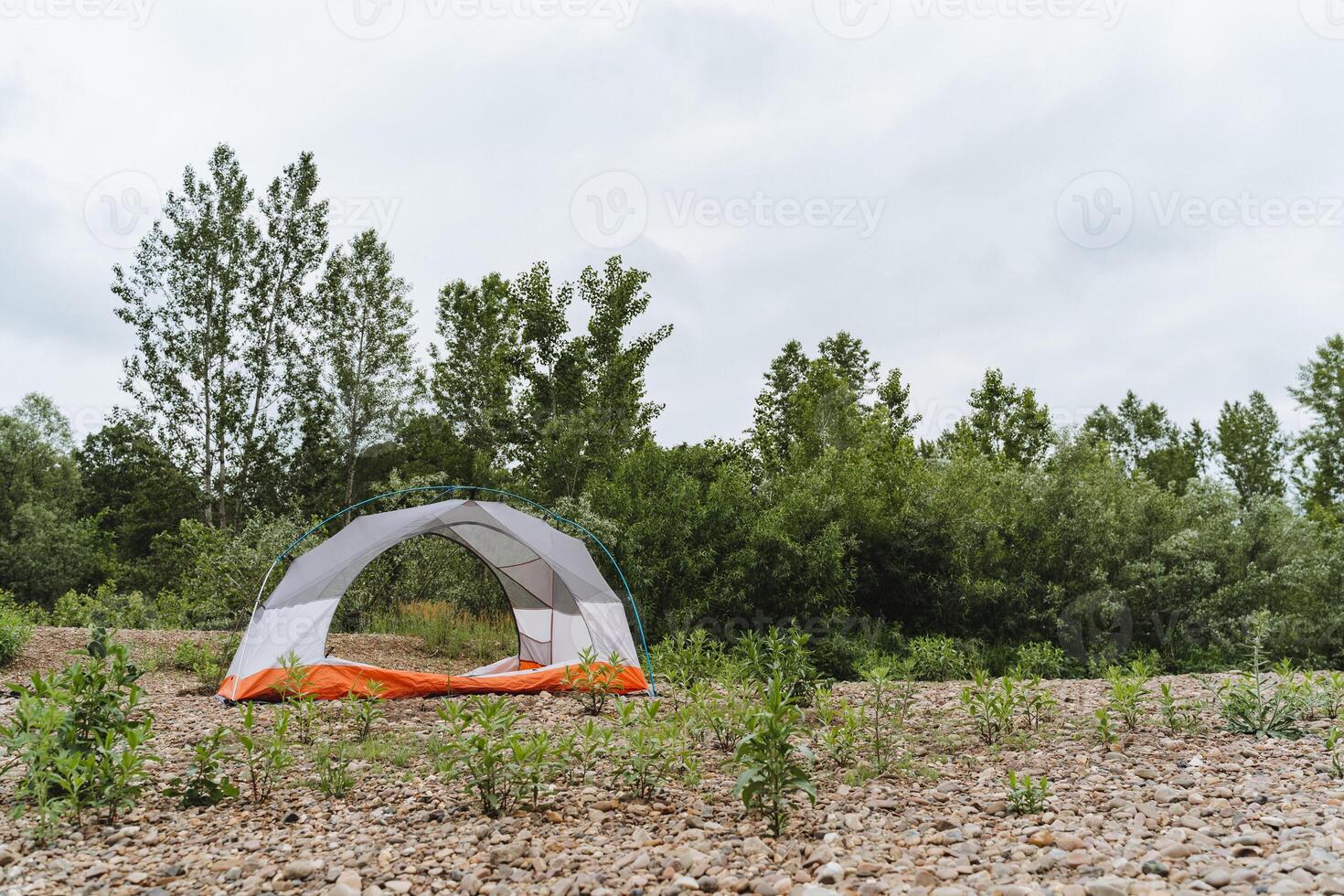 Immerse yourself in a camping adventure by setting up a tent in peaceful natural surroundings, away from the city. Explore nature and find serenity in the wilderness photo