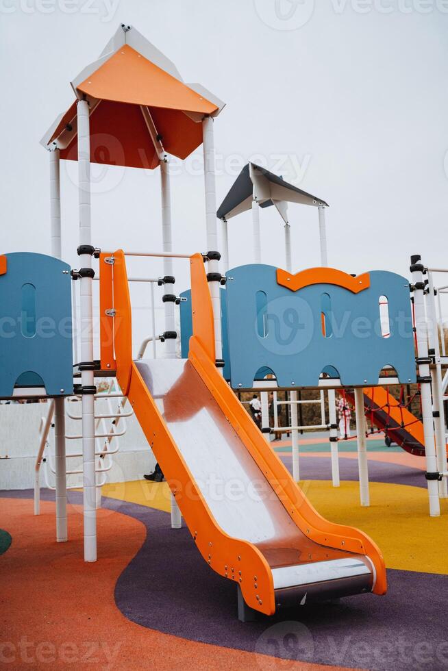 This vibrant and exciting playground features a large, colorful slide and a tall, imaginative structure, all designed specifically for kids to enjoy a safe and fun outdoor recreational area photo