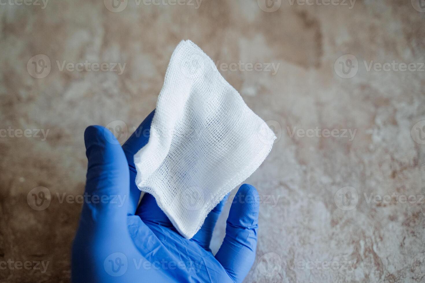 A person wearing bright blue gloves is meticulously and carefully holding onto a delicate piece of soft tissue, ensuring that it is treated with the utmost attention, care, and precision photo