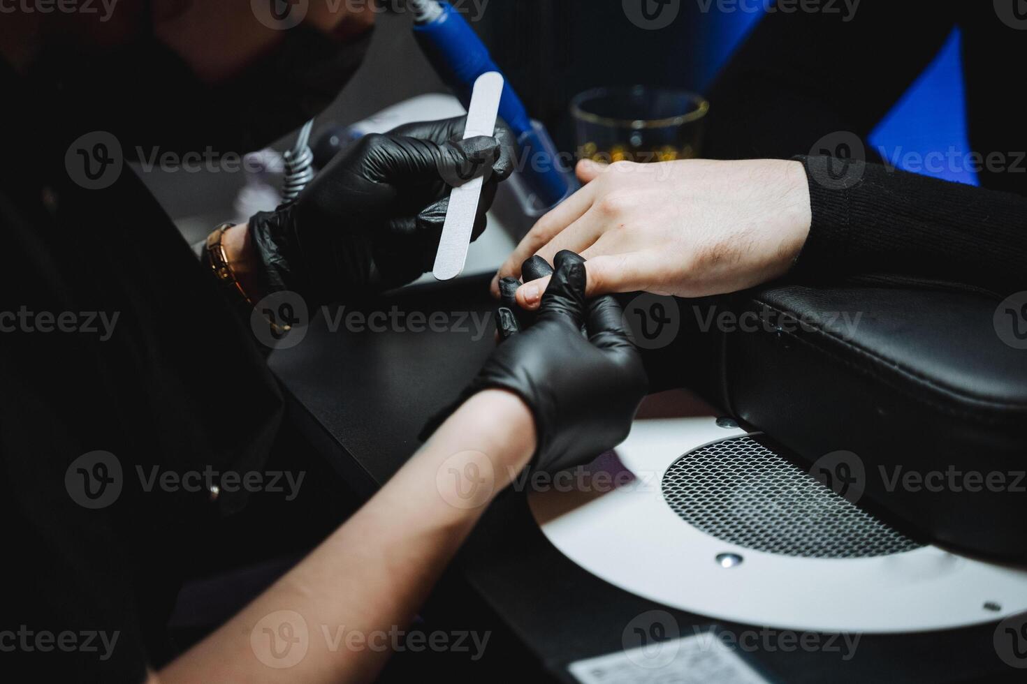 Hand care procedure in a nail salon, top view as a man gets a manicure using the hardware method. photo