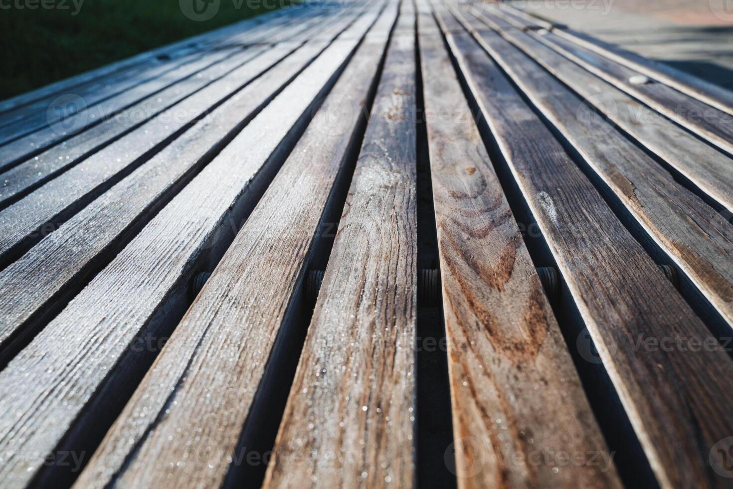 This image features a closeup view of a beautifully crafted wooden deck that showcases a striking diagonal pattern, emphasizing the unique textures and hues of the wood surface photo