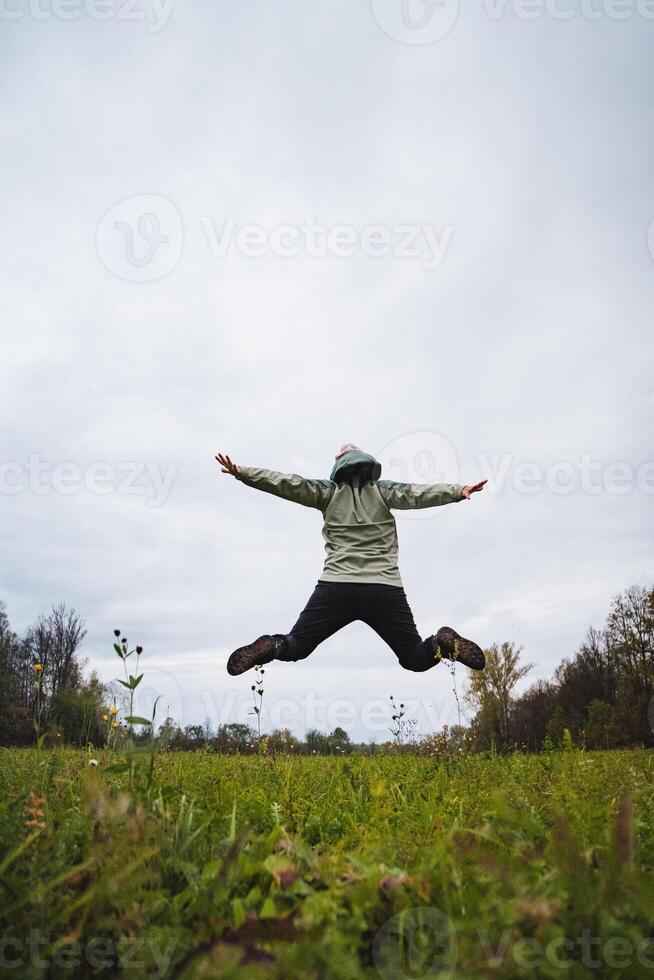 A highenergy dynamic jump takes place against a bright, vivid sky in a beautifully scenic outdoor location full of nature all around photo