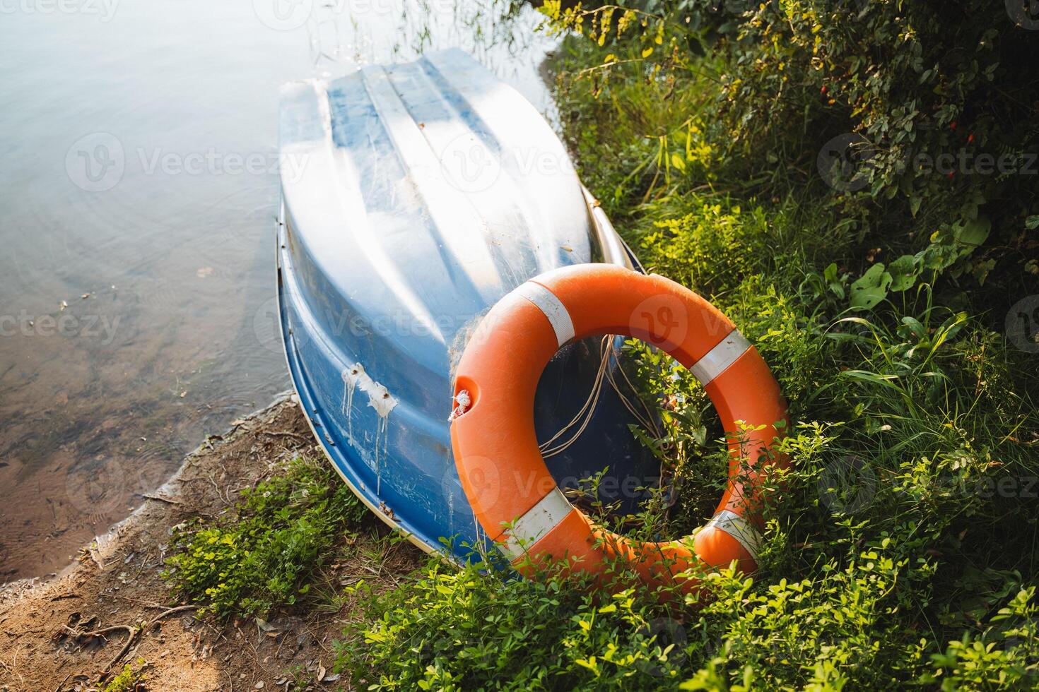 A bright orange life preserver is positioned on the edge of a boat for quick access, ready to ensure the safety of those enjoying their time on the water in case of an emergency photo