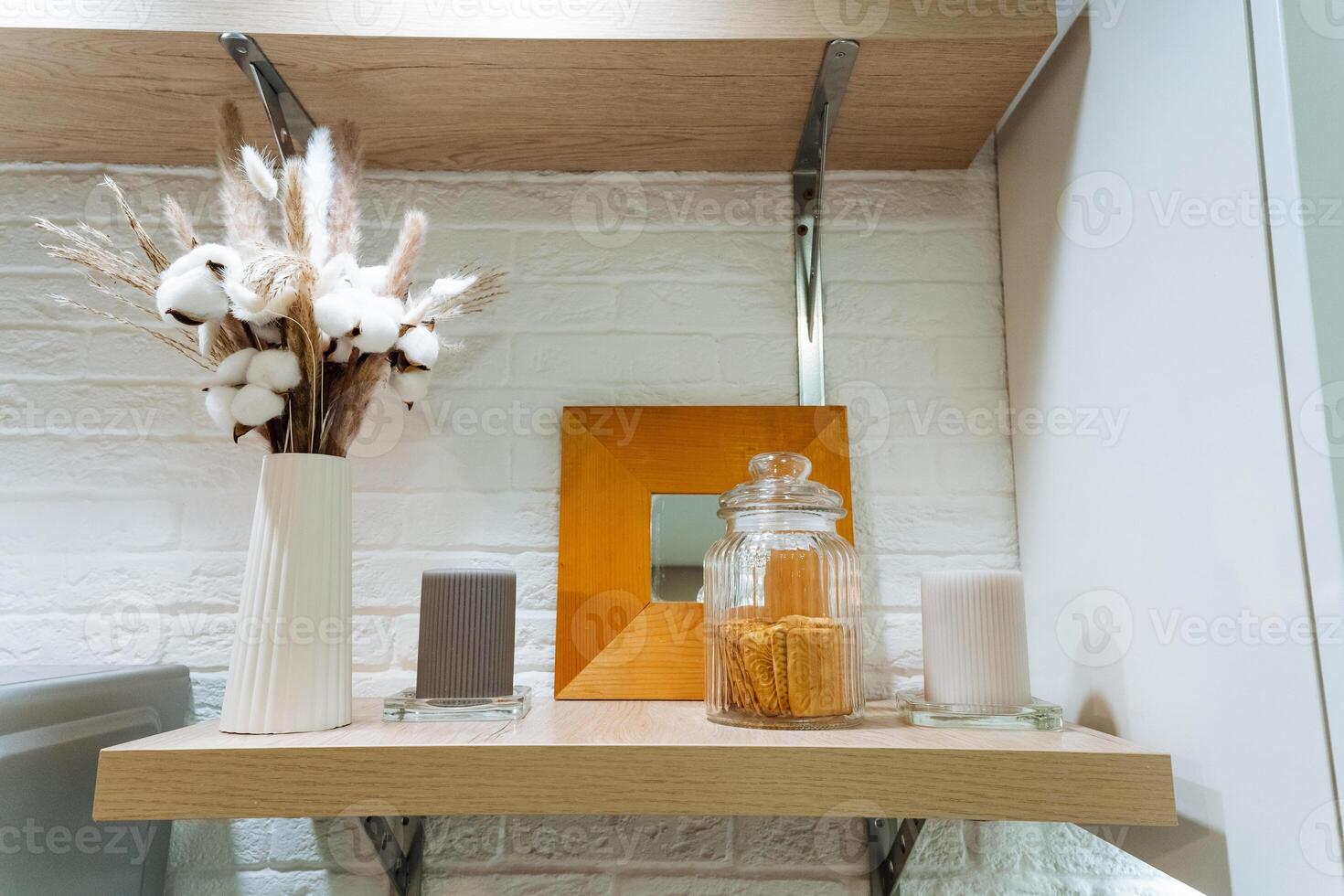 A beautifully crafted wooden shelf that features a stylish vase filled with vibrant flowers and several elegant candles arranged on its surface, enhancing the rooms aesthetic appeal photo