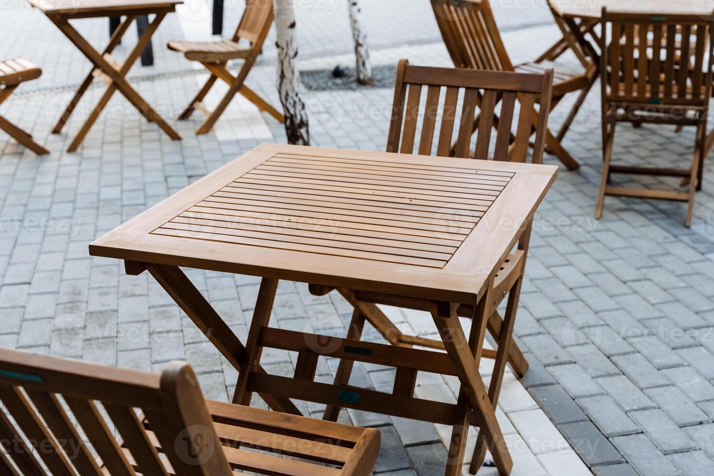 Outdoor furniture set, wooden folding tables and chairs on sidewalk photo